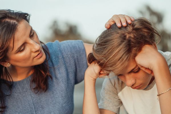 Mamá hablando con su hijo adolescente sobre la importancia del uso equilibrado del celular.